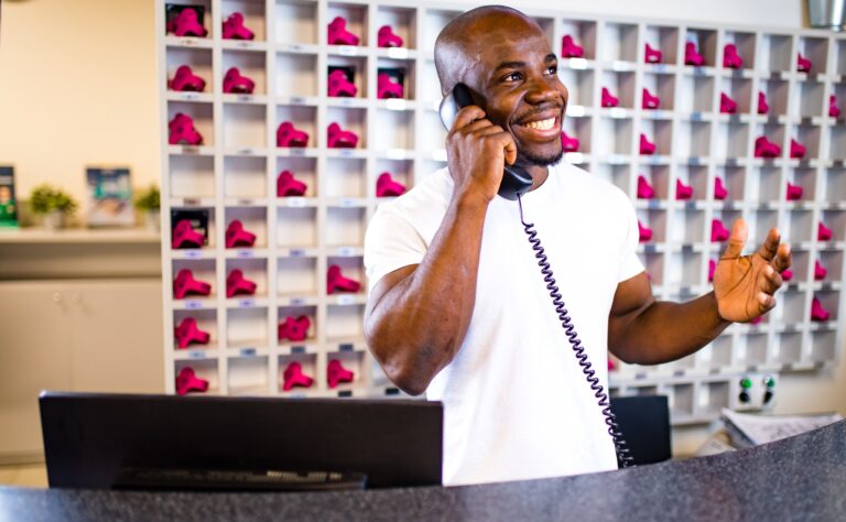 Mitarbeiter am Empfang eines Fitnessstudios telefoniert